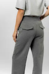 Pantalón blanco de silueta amplia y caída fluida, con cintura alta elastizada y lazo regulable con terminaciones metálicas.