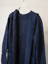 Saco abierto de paño en color azul marino, con diseño de solapas anchas y bolsillos frontales. Presenta una textura suave y cálida, ideal para la temporada de invierno.