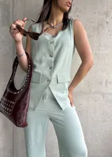 Chaleco verde agua con escote en V, sin mangas y cierre frontal con botones.