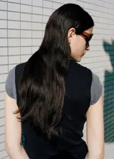 Top negro de algodón con cuello redondo y mangas cortas, con fucsia y detalle de lazo integrado para atar en la cintura.