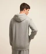 Buzo deportivo negro con capucha, cierre frontal con cremallera, bolsillos laterales y puños ajustados. Confeccionado en tejido de algodón y poliéster.