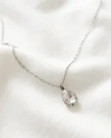 Collar plateado con dije en forma de lágrima de cristal facetado.