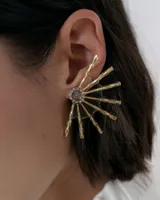 Caravanas tipo ear cuff con diseño de medio sol, compuestas por varillas metálicas plateadas, centro con strass y detalle de resina. Diseño liviano y brillante.