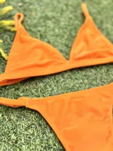 Conjunto de bikini naranja, con corpiño triangular fijo y bombacha vedetina regulable.