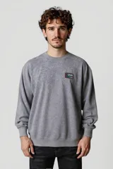 Buzo gris oscuro con cuello redondo y parche con la bandera de Estados Unidos en el pecho.