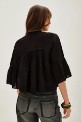 Camisa de algodón color negro, con cuello redondo, mangas tres cuartos abullonadas y detalles de encaje y alforzas en el frente y mangas.