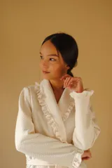 Bata larga color blanco, confeccionada en algodón capitoneado con diseño de espiga. Presenta volados en el cuello y puños, y lazo de ajuste en la cintura.