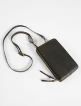 Porta celular con correa larga regulable, confeccionado en cuero vegano color marrón oscuro. Tiene doble compartimento con cierre y tarjetero en el interior.