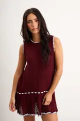 Vestido corto de punto color bordó con detalles en celeste claro en el cuello, sisas y el ruedo, sin mangas y con diseño evasé.