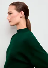 Jersey de punto fino color verde oscuro, con cuello perkins, manga larga y diseño entallado con detalle de lazo anudado en la cintura.