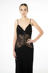 Vestido largo negro de silueta fluida con delicado encaje floral y transparencias estratégicas en el torso. Escote profundo con breteles finos.