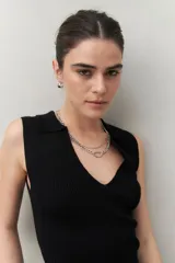 Top negro tejido sin mangas con escote en V y cuello tipo solapa.