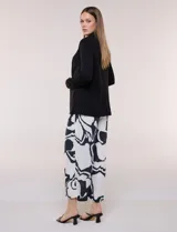 Blazer negro desestructurado de confección liviana y caída fluida, con cuello smoking, solapa corrida y mangas largas.