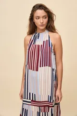 Vestido largo de silueta amplia y caída fluida, con escote halter fruncido y falda con recorte. Presenta diseño geométrico multicolor a rayas en tonos bordó, azul, celeste y beige.