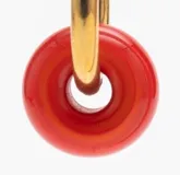 Aros tipo argolla pequeña en oro con dije colgante en forma de dona de vidrio color rojo.