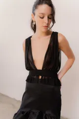 Top de microtul color marrón con escote profundo, diseño cruzado y faja en la cintura con detalle de volados en el ruedo. Presenta una estructura de doble capa para mayor opacidad y ajuste regulable en la espalda.