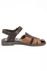 Sandalias cangrejeras de cuero tipo flats, con diseño bicolor en tonos marrón y tostado, tiras entrelazadas en el empeine y tira ajustable con hebilla en el talón.