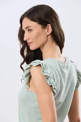 Remera de algodón azul melange con escote redondo y mangas cortas adornadas con doble volado de broderie en los hombros.