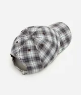 Gorra de aba curva confeccionada en franela de algodón, con diseño a cuadros en tonos gris, celeste y blanco, paneles estructurados y cierre regulable trasero con hebilla metálica.