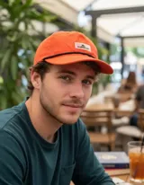 Gorra Quiksilver modelo Flow States de color naranja ladrillo, con visera curva, cordón negro decorativo sobre el ala y parche frontal con el logo de la marca.