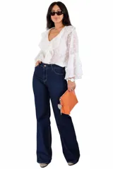 Pantalón de jean azul oscuro con corte wide leg, tiro alto y costuras en contraste color camel.