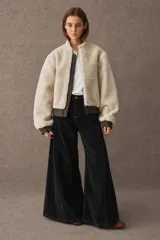 Pantalon de pana de corte wide leg, color negro, con costuras a la vista en tono contrastante y cintura alta.