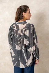 Camisa oversize con estampado abstracto en tonos marrones y beige, cuello mao y cierre frontal con botones. Presenta mangas largas anchas con puños abotonados y un corte holgado.