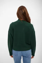 Sweater de punto con cuello alto, manga larga y diseño holgado.