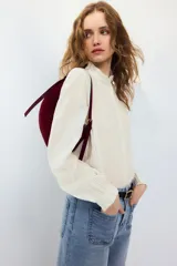 Blusa de mezcla de algodón y viscosa, color blanco con diseño a rayas finas oscuras, cuello alto con volados y mangas largas con puños elastizados con volados.