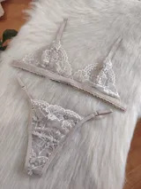 Conjunto de lencería compuesto por un bralette triangular de encaje con breteles regulables y una tanga a juego con laterales ajustables.