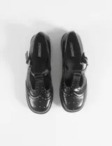 Mocasines negros de cuero vegano con detalle de tachas plateadas en la parte delantera.