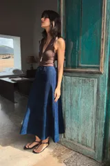 Body entallado color marrón oscuro con escote pronunciado en pico y manga sisa. Cierre en la parte inferior con botones a presión.