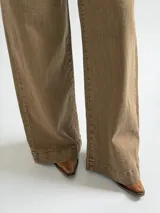 Jean de corte recto y tiro medio, en color camel con acabado desgastado. Presenta diseño clásico de cinco bolsillos, cierre frontal con botón y cremallera, y costuras reforzadas en el ruedo.