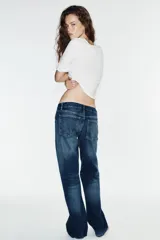 Jeans wide leg de tiro bajo y cinco bolsillos con efecto lavado y cierre frontal con cremallera y botón metálico.