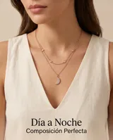 Collar doble de plata 925 con baño de oro rosa. La cadena superior presenta pequeñas circonias engastadas, mientras que la cadena inferior incluye un dije en forma de luna creciente pavé con circonias blancas.
