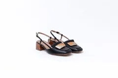 Zapato de cuero blanco con taco de madera, talón descubierto y pulsera con hebilla. Aplique decorativo en la capellada.