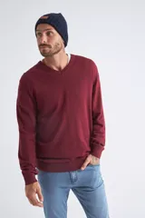 Sweater de tejido de punto color beige, con escote en V, mangas largas y puños y dobladillo acanalados. Presenta un pequeño logo bordado en el pecho.