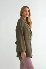 Chaqueta de gamuza sintética color bordó, con cuello solapa, cierre frontal de botones y cinturón ajustable del mismo material. Posee bolsillos frontales y mangas largas.