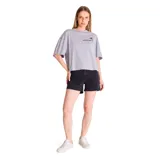 Remera gris de corte amplio con mangas cortas y ruedo recto. Presenta un pequeño estampado con el logo de Caterpillar y una flor en el lado izquierdo del pecho.