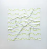 Pañuelo de seda blanco con estampado de líneas curvas en color verde lima, y texto sutil en la tela.