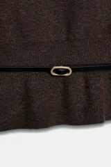 Jersey de punto color mostaza con cuello barco, manga larga con sisa ancha y detalle de cinturón fino integrado en la cintura.