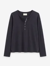 Remera de algodón con spandex, color negro, de manga larga y ajuste al cuerpo. Presenta un escote redondo con cartera frontal de botones y detalle de cordón decorativo en contratono.