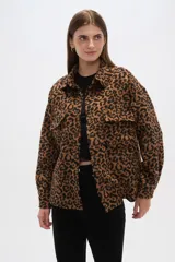 Chaqueta tipo camisa de corte holgado con estampado animal print, cuello camisero, cierre frontal con botones y bolsillos de parche en el pecho.
