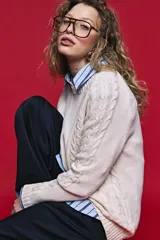 Sweater de tejido de punto negro con tramas de ochos en las mangas y laterales, cuello redondo a la base y mangas largas.