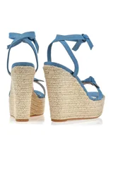 Sandalias con plataforma de yute y tiras de tela celeste con estampado tie-dye.