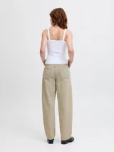 Jean de corte barrel fit con tiro medio, confeccionado en denim de sarga con un lavado teñido en tono beige. Presenta pierna suelta, cierre con bragueta y diseño de cinco bolsillos.