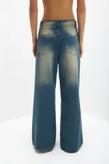 Pantalón de jean azul con efecto gastado, corte wide leg y roturas.