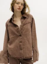 Campera de denim gastado color marrón, de corte holgado y ligero, con cuello camisero, cierre frontal de botones y detalles de botones en los puños.
