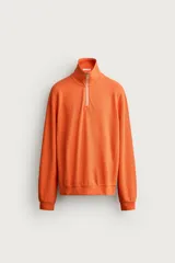 Sudadera regular fit color naranja, confeccionada en tejido de algodón con estructura piqué. Presenta cuello subido con cierre frontal de cremallera, manga larga y acabados en rib.