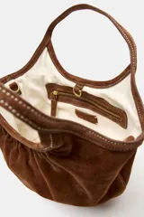 Bolso de hombro formato mini shopper confeccionado en piel, con diseño fruncido, doble asa de mano con pespuntes decorativos y cierre mediante clip metálico.